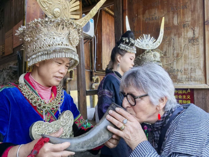Elderly woman drinks from horn